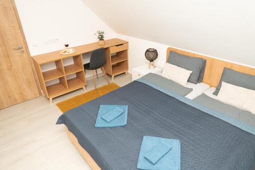 a bedroom with a bed with two blue envelopes on it at Chalupa U Juzka in Loučná nad Desnou