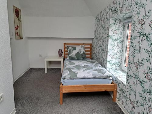 - une petite chambre avec un lit et une fenêtre dans l'établissement Kniepwiekerhof, à Neukamperfehn