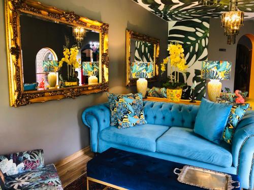 a living room with a blue couch and mirrors at Grafiti Boutique Hotel in Bela-Bela