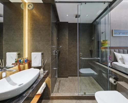 a bathroom with a glass shower and a sink at Moyrah By Greenpark in Anjuna
