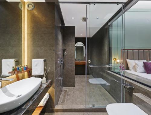 a bathroom with a tub and a sink and a shower at Moyrah By Greenpark in Anjuna