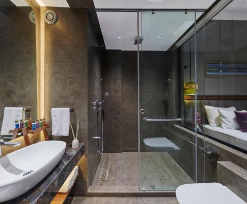 a bathroom with a glass shower and a sink at Moyrah By Greenpark in Anjuna