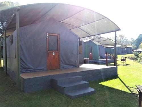 a blue tent with stairs in a yard at Sabie River Camp in Sabie