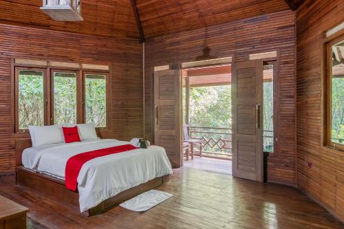 een slaapkamer met een bed in een kamer met houten wanden bij RedDoorz Resort @ Taman Wisata Mangrove in Jakarta