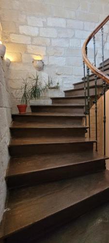 un escalier avec des marches en bois et un mur en briques dans l'établissement Studio Sommieres, à Sommières