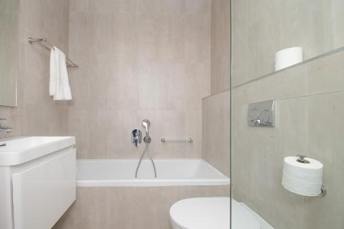 a bathroom with a tub and a toilet and a sink at 210 Breakers Resort Umhlanga Rocks in Durban