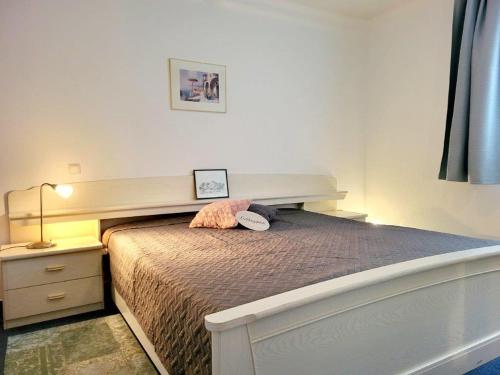 キュールングスボルンにあるAppartementhaus Olympのベッドルーム1室(大型ベッド1台、木製ヘッドボード付)
