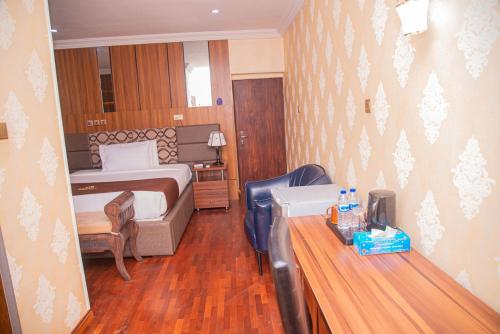 a hotel room with a bed and a desk with a desk at MAHOGANY HOTEL AND SUITES in Ibadan