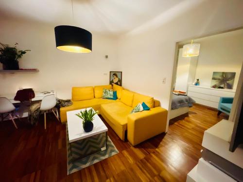 a living room with a yellow couch and a table at Cosy flat with huge Terrasse! Long or Shortterm in Vienna