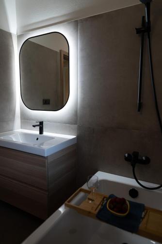 a bathroom with a sink and a mirror and a tub at Chalupa U Juzka in Loučná nad Desnou