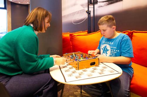 a woman and a boy playing a board game at ibis Berlin City Potsdamer Platz in Berlin
