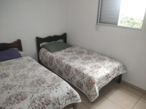 1 dormitorio con 2 camas y ventana en Apartamento bem localizado en Franca