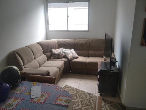 a living room with a couch and a television at Apartamento bem localizado in Franca