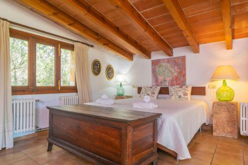 a bedroom with a bed with a dresser in it at Garriga d'Alcudiola in Santa Margalida