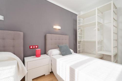 a bedroom with two beds and a closet at Antic 302 in S'Illot