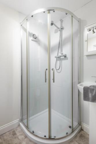 a glass shower in a bathroom with a sink at Bluegrass Cottage - Free parking in Whitby