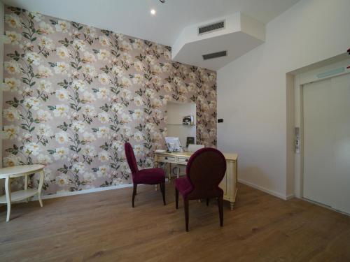 a room with a desk and two chairs and a table at Castiglioncello Suite in Castiglioncello