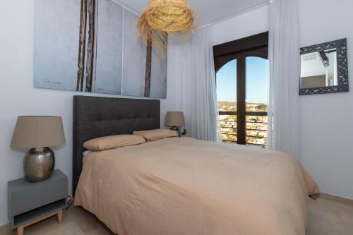 a bedroom with a large bed and a window at Atico Gran Sol in Rincón de la Victoria