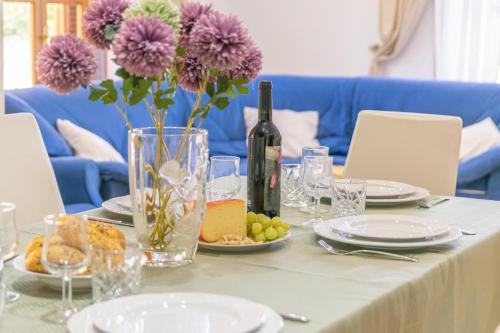 a table with a bottle of wine and flowers on it at Pomeres 9 in Sa Coma