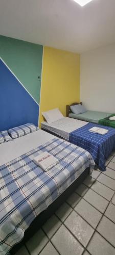 duas camas sentadas uma ao lado da outra num quarto em Hotel Beira Mar em Natal