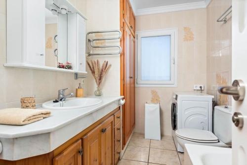 a bathroom with a sink and a toilet and a window at Villa Bienvenidos in Son Bou