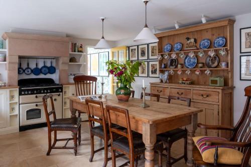 uma cozinha com uma mesa de madeira e cadeiras em Bert's - your idyllic Derbyshire retreat em Bonsall