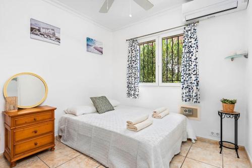 a bedroom with a bed and a mirror and a dresser at Villa Bienvenidos in Son Bou