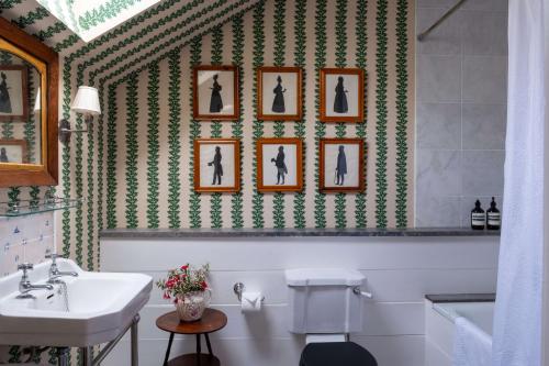 uma casa de banho com lavatório e quadros na parede em Bert's - your idyllic Derbyshire retreat em Bonsall
