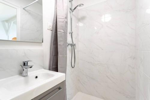 a white bathroom with a shower and a sink at Au bord du canal G *Paris*Disney*Gare* in Chelles