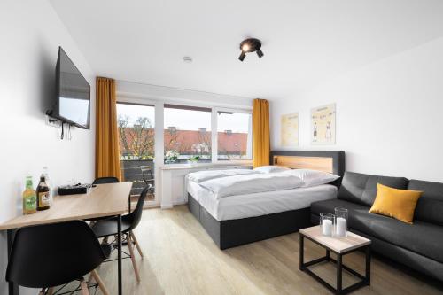 ein Hotelzimmer mit einem Bett und einem Sofa in der Unterkunft Homaris Apartments München Laim in München