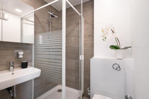 y baño con ducha y lavamanos. en Homaris Apartments München Laim, en Múnich