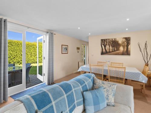 a living room with a couch and a dining room with a table at Ash Tree Cottage in Bosherston