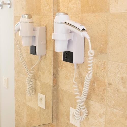 - un téléphone blanc suspendu au mur dans la salle de bains dans l'établissement Hotel La Ciotat - A deux pas de l'eau, à La Ciotat