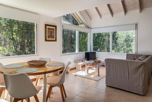 - un salon avec une table, des chaises et des fenêtres dans l'établissement Happy Host-Casas Cruz del Sur, à Villa La Angostura