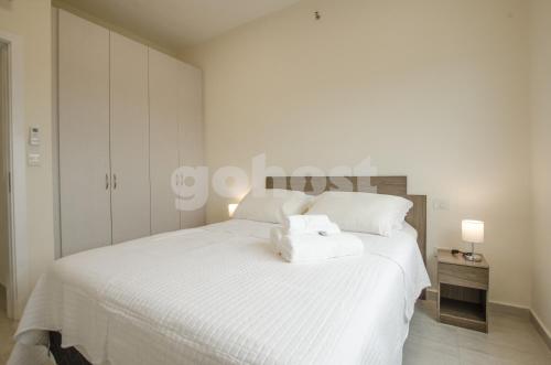 a white bedroom with a large bed with white sheets at Comfortable Apartment Close To Shopping Mariscal in Asunción