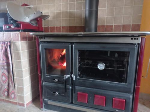 a black stove with a fire inside of it at Famiglia nel vento in Caramanico Terme