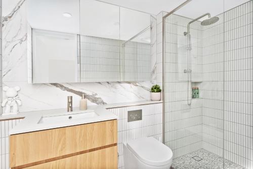 a white bathroom with a toilet and a shower at Kashmir, Modern and luxury 2BR 2BA, Fast WiFi & Netflix, Free Parking, Central Location, near CBD in Canberra