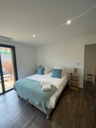 萊格卡弗爾雷的住宿－Petite maison proche de la plage，一间卧室配有一张带蓝色枕头的床。
