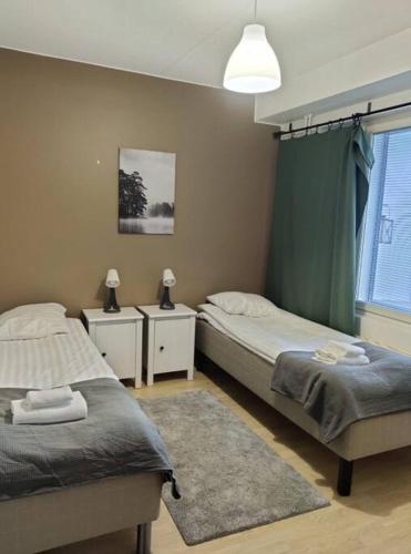 una camera da letto con due letti e una finestra di Kotimaailma- Kalustettu kaksio Rauhallisella alueella Hiekkaharjusta a Vantaa