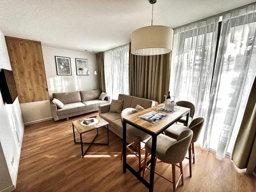 a living room with a table and a couch at Jantaris B1 - Apartament 20m od plaży in Mielno