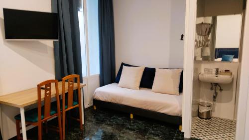 a small room with a bed and a table and a sink at Hostal Bruña Paseo del Prado in Madrid