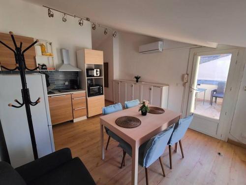 une cuisine et une salle à manger avec une table et des chaises bleues dans l'établissement Appartement 2 chambres Terrasse, à Orange