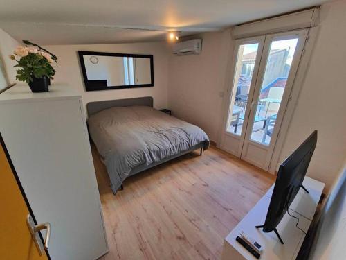 - une chambre avec un lit et un bureau avec un ordinateur dans l'établissement Appartement 2 chambres Terrasse, à Orange