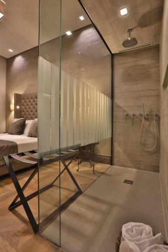 a glass shower in a bedroom with a bed at Forvm Experience in Trieste