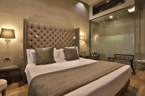 um quarto com uma cama grande e uma grande cabeceira. em Forvm Experience em Trieste