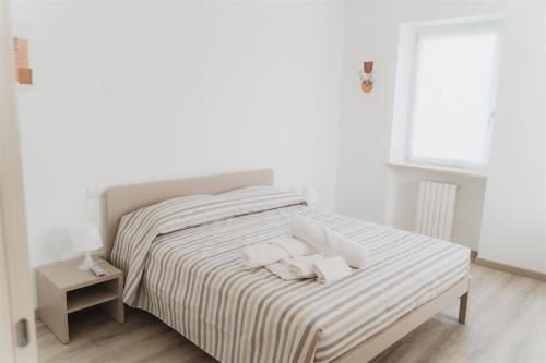 a white bedroom with a bed with towels on it at Civiconr3 in Sona