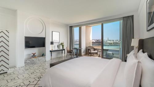 a bedroom with a large white bed and a large window at Fairmont La Marina Rabat Sale Hotel in Rabat