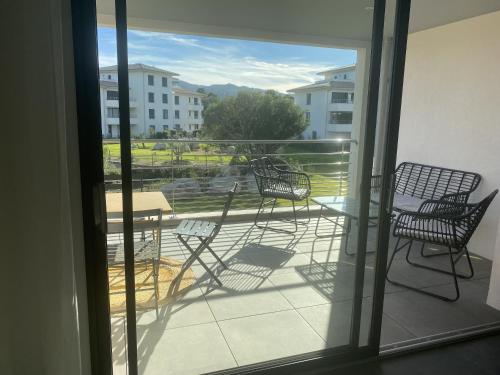 une vue d'un balcon avec des chaises et une table dans l'établissement Domaine d'Arca - Flaubert 11 - 4 pers - étage 1, à Porto-Vecchio