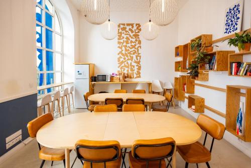a room with tables and chairs and a kitchen at The People - Marseille in Marseille