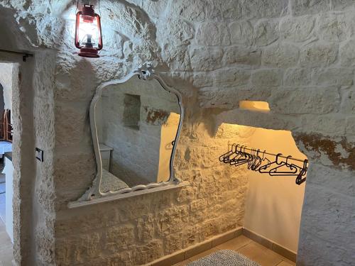 a bathroom with a mirror and a light on the wall at RocknTrullo 2 bedroom by TripOstuni in Ostuni